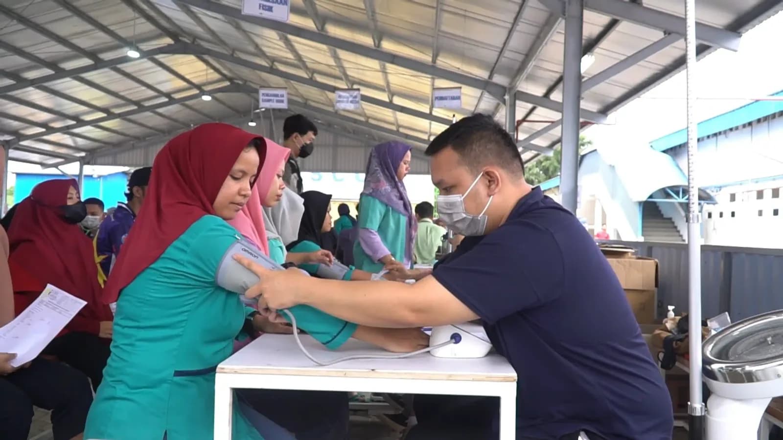 A health worker measuring a participant's blood pressure during a mass medical check-up