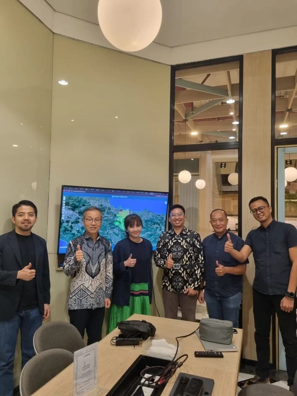 Diskusi perencanaan program bersama mitra di depan layar dashboard pemetaan